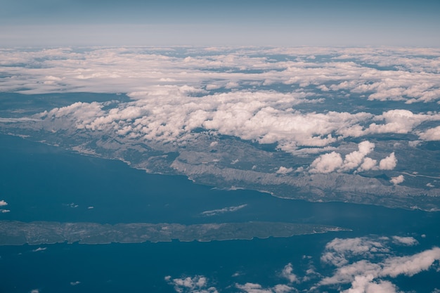 Blick aus dem Flugzeug über den Wolken über die Küste Kroatiens