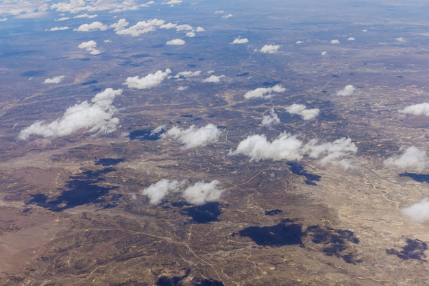 Blick aus dem Flugzeug während des Fluges über flauschige Wolken in der Wüste von New Mexico, USA