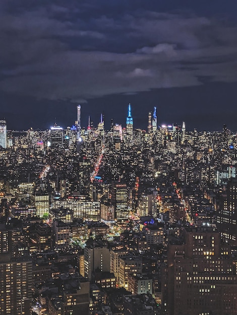 Blick aus der Vogelperspektive auf beleuchtete Gebäude in der Stadt bei Nacht