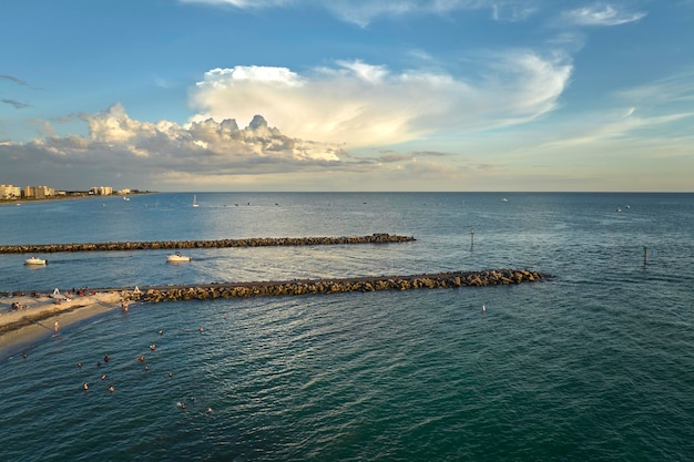 Blick aus der Vogelperspektive auf den überfüllten Nokomis-Strand in Sarasota County, USA Viele Menschen genießen die Urlaubszeit, schwimmen im Meerwasser und entspannen sich bei Sonnenuntergang in der warmen Sonne Floridas