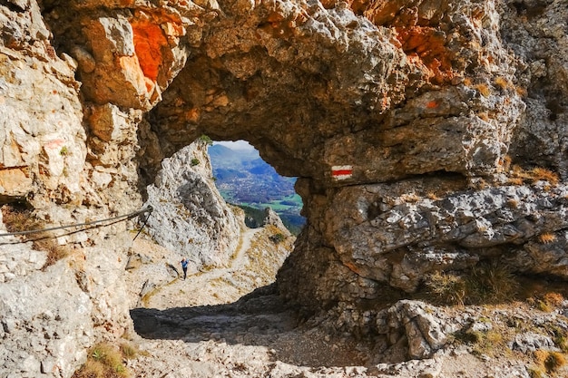 Blick durch einen runden Felsdurchgang mit einem Schild aus Österreich