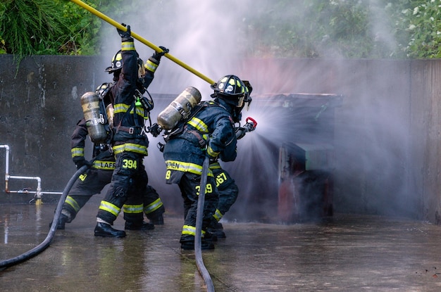 Blick hinten auf einen Feuerwehrmann, der einen Wasserschlauch benutzt