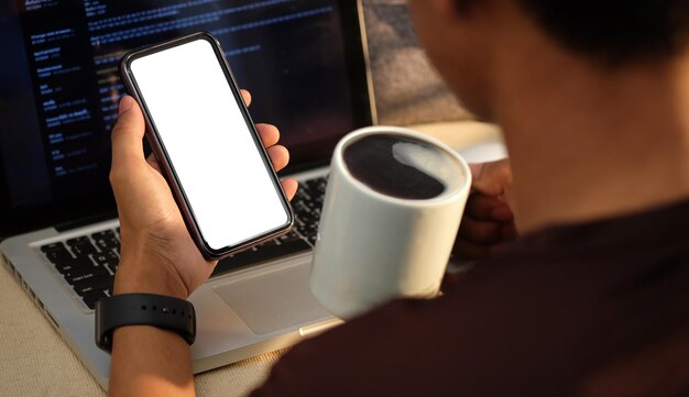 Blick über die Schulter junger Mann trinkt Kaffee und benutzt Handy