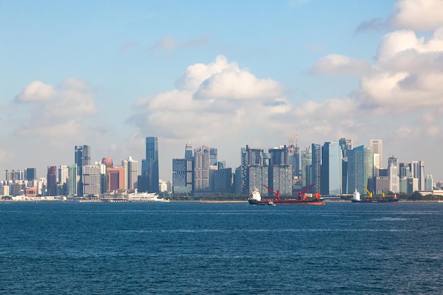 Blick vom Meer nach Singapur mit Hochhäusern und der Küste und Transportschiffen am Anker