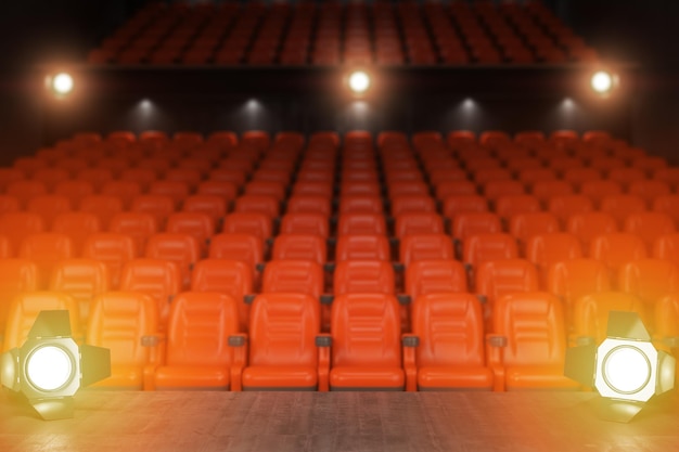 Blick von der Bühne eines Konzertsaals oder Theaters mit roten Sitzen und Scheinwerferlicht