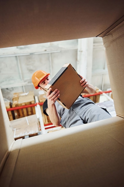 Blick von der Innenseite des Papierkastens. Lagerarbeiter im Schutzhelm haben einen Job.