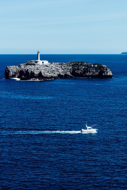 Blick von der Magdalena-Halbinsel Santander Spanien mit einem kleinen Segelboot und der Insel Mouro im Hintergrund mit ihrem Leuchtturm aus dem 19. Jahrhundert