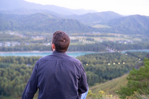 Blick von der Spitze des Berges. Ein Mann betrachtet die Natur vom Berg aus. Bergreise