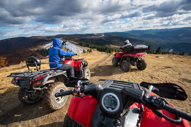 Blick von einem Quad mit Männern, die mit einem ATV vorne auf den Bergpfad fahren