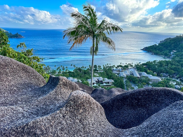 Blick von einer hohen Klippe auf die türkisfarbene Bucht des Indischen Ozeans auf den Seychellen