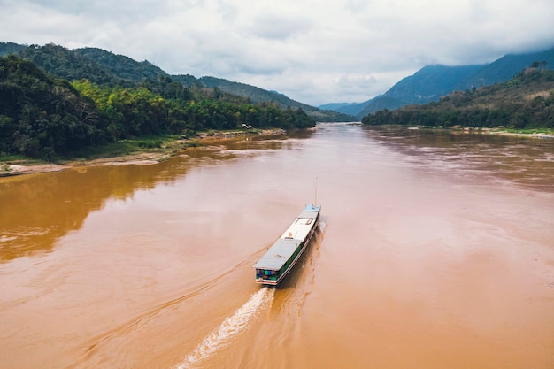 Blick von oben Atemberaubende Luftaufnahme eines traditionellen Longtail-Boots, das auf dem Mekong Luang Prabang Laos segelt