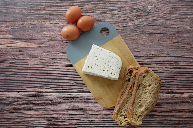 Blick von oben auf blauen Käse und eine Scheibe braunes Brot auf dem Tisch