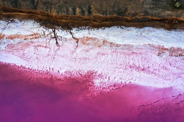 Blick von oben auf das salzbedeckte Ufer des Pink Lake