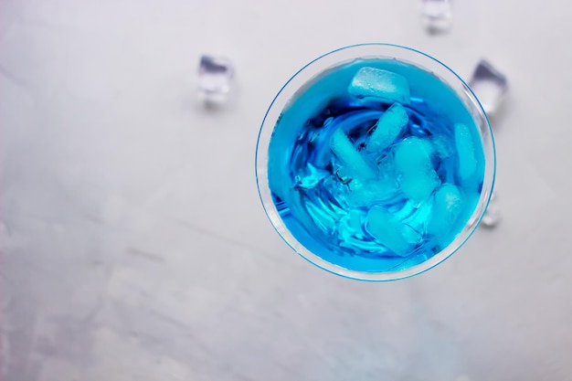 Blick von oben auf den blauen Cocktail im Martini-Glas mit Eiswürfeln