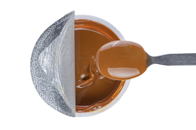 Blick von oben auf den Löffel, der Dulce de Leche aus einem traditionellen süßen Topf aus Argentinien schöpft