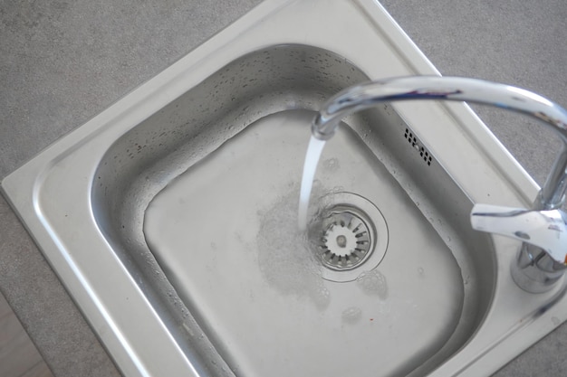 Blick von oben auf den Wasserhahn mit fließendem Wasser