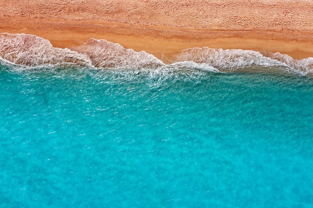 Blick von oben auf die Brandungslinie am Sandstrand