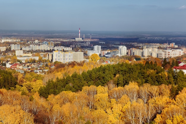 Blick von oben auf die Stadt und den bunten Herbstwald