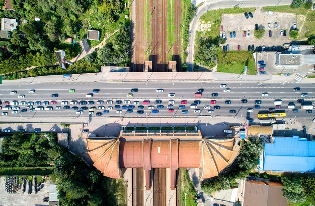 Blick von oben auf eine Straßenbrücke, die eine Eisenbahn überquert. Bahnhof Karavaevi Dachi - Kiew, Ukraine