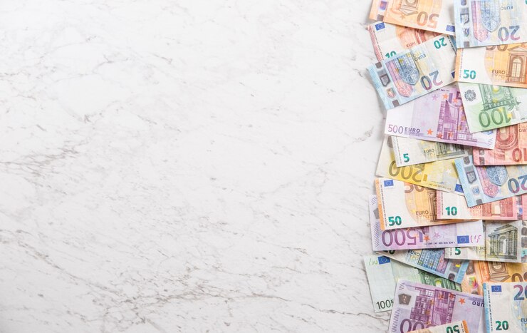 Blick von oben auf einen Haufen Euro-Banknoten auf Marmortisch.