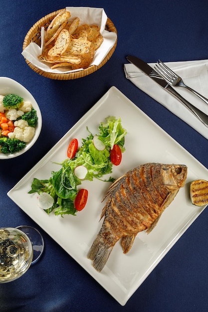 Blick von oben auf Karpfenfische auf weißem Teller im Restaurant