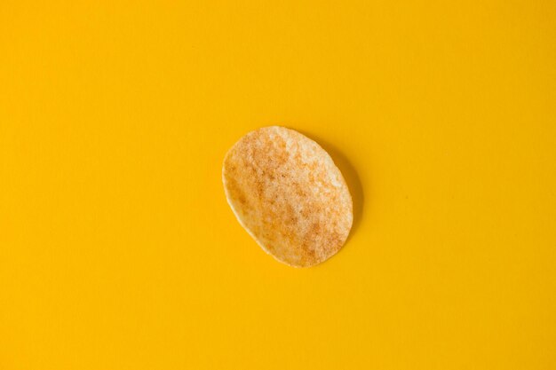 Blick von oben auf köstliche gebratene und salzige Kartoffelchips auf Gelb