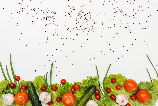 Blick von oben auf leckere Tomaten, Salatblätter, Gurken, Zwiebeln, Gewürze und Knoblauch