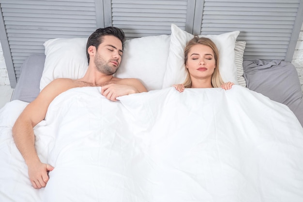 Blick von oben auf Mann und Frau, die zusammen im Bett schlafen