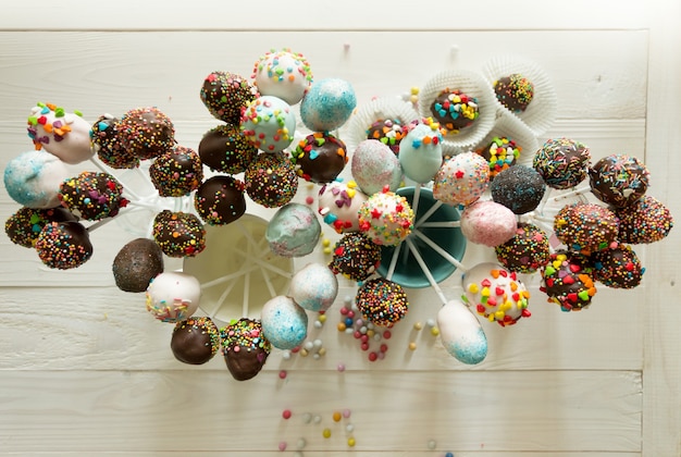 Blick von oben auf schöne bunte Cake Pops auf Holztisch