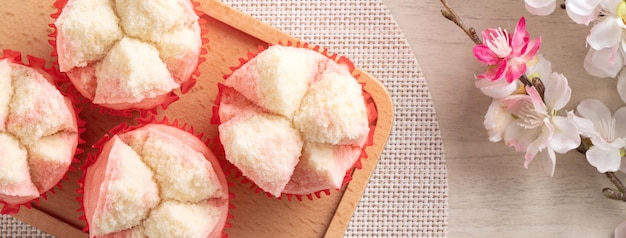 Blick von oben auf süßen, leckeren, frischen traditionellen chinesischen gedämpften biskuitkuchen fa gao auf holztischhintergrund für frühlingsfestfeiern in rosa und weißer farbe