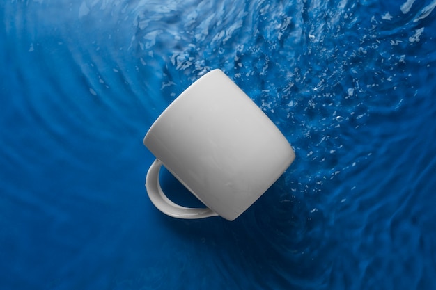 Blick von oben über eine auf dem Wasser schwimmende Tasse