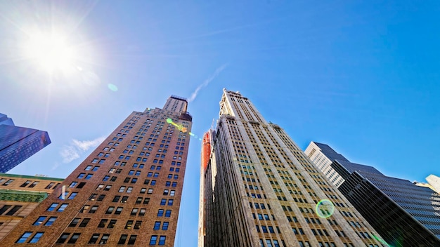 Blick von unten auf die Skyline von Manhattan mit Wolkenkratzern. In New York, USA. An einem sonnigen Tag. Mit spezieller Sonneneruption