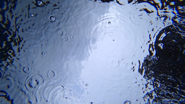 Blick von unter Wasser auf den Himmel und Regen