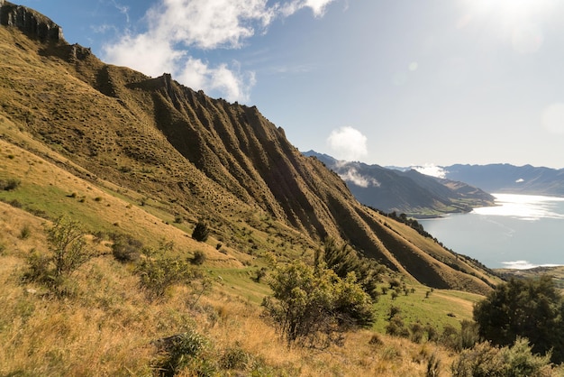 Blicken Sie von den Hängen des Tages auf den Lake Hawea und wandern Sie die steilen Hänge des Isthmus Peak hinauf