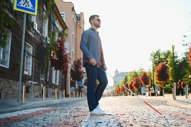 Blinder junger Mann beim Überqueren der Straße