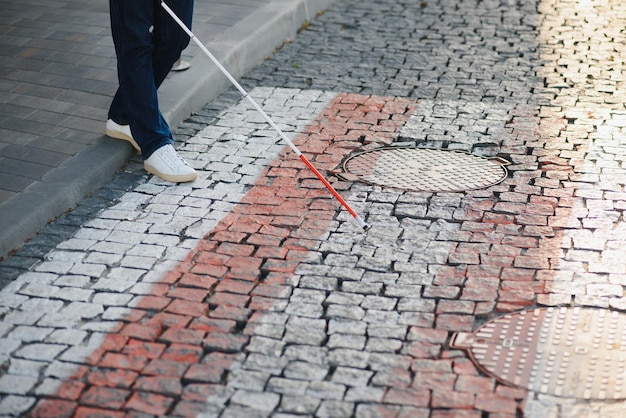 Blinder junger Mann beim Überqueren der Straße