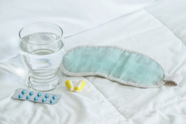 Blister de comprimidos para dormir, venda e copo de água