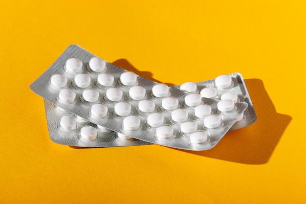Blisterpackung mit Pillen auf gelbem Hintergrund