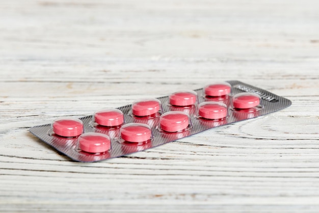 Blisterpackung mit Vitamin auf farbigem Hintergrund Medizinpillen auf hellem Hintergrund Medikamente und verschreibungspflichtige Pillen liegen flach im Hintergrund Rosa medizinische Tabletten in Blister