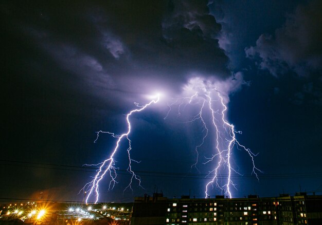 Foto blitz über der beleuchteten stadt gegen den himmel in der nacht.