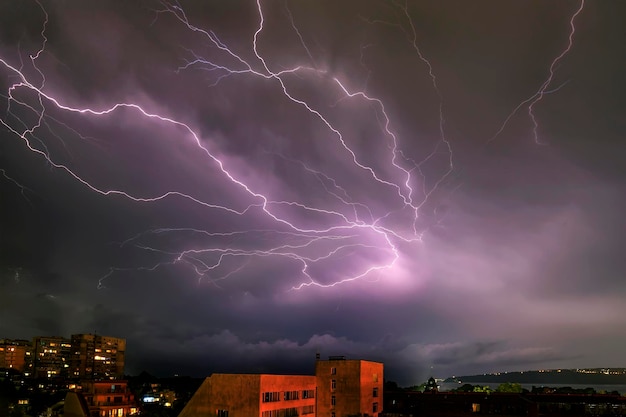 Blitze über beleuchteten Gebäuden in der Stadt in der Nacht