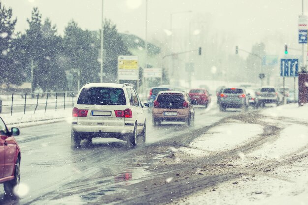 Blizzard na estrada de pouca visibilidade, carros com luzes na encruzilhada.