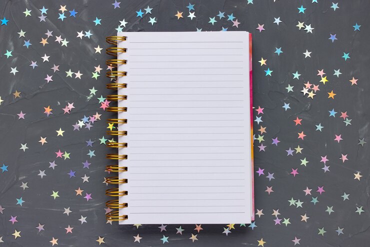 Foto bloc de notas abierto en negro festivo con estrellas de colores. concepto de lista de tareas pendientes