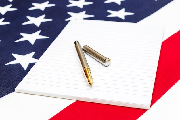 Bloc de notas con bolígrafo en la bandera americana
