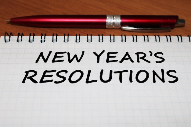 bloc de notas con un bolígrafo en una mesa de madera vista desde arriba el concepto de resoluciones para el nuevo año