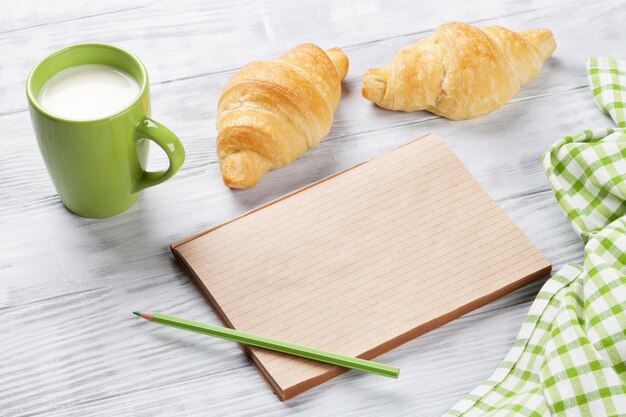 Bloc de notas y leche fresca croissants