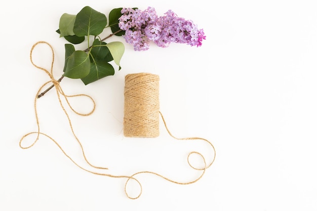 Bloc de notas limpio con flores lilas de primavera sobre fondo blanco de madera