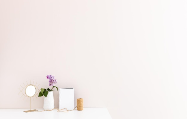 Bloc de notas limpio con flores lilas de primavera sobre fondo blanco de madera