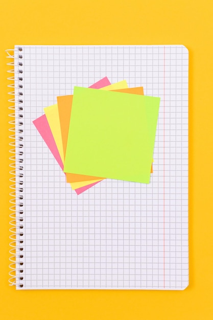 Foto un bloc de notas con notas adhesivas en el cuadro amarillo