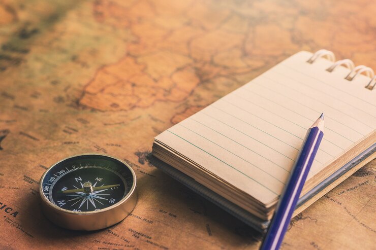 Bloc de notas para notas con lápiz, brújula en el mapa de papel para la imagen de descubrimiento de aventura de viaje